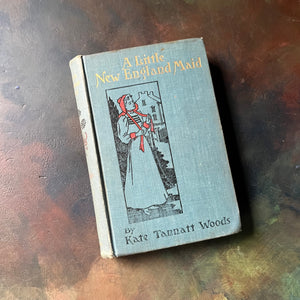 A Little New England Maid by Kate Tannatt Woods-1898 Edition-vintage living book-vintage children's chapter book-view of the front cover - embossed with an image of the main character of the book