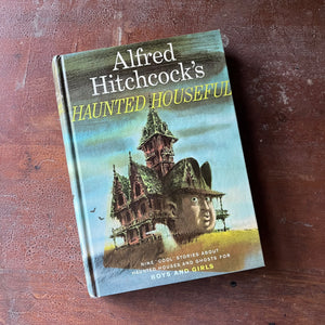 vintage mystery book for children - Alfred Hitchcock's Haunted Houseful written by Alfred Hitchcock with illustrations by Fred Banbery - view of the front cover with an old house with a ghost in front of it & Alred Hitchock's face coming out of the house - this is his iconic illustration for these children's books - his face coming out of the illustration