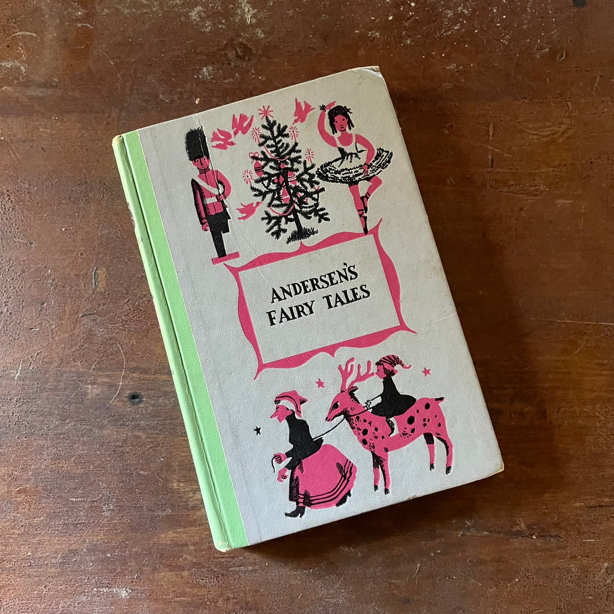 vintage children's chapter book - Andersen's Fairy Tales-A Junior Deluxe Editions Book - view of the embossed front cover with pink & black illustrations taken from the stories in the book