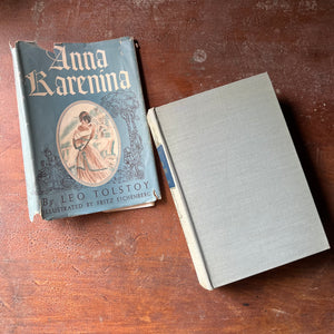 classic literature, Russian Literature, Top 100 Must Read Classic Literature Book - A vintage edition of Anna Karenina written by Leo Tolstoy with illustrations by Fritz Eichenberg sit on a patinaed wood table with the view of the front cover shown with the dust jacket sitting next to the book