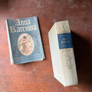 classic literature, Russian Literature, Top 100 Must Read Classic Literature Book - A vintage edition of Anna Karenina written by Leo Tolstoy with illustrations by Fritz Eichenberg sit on a patinaed wood table with the view of the spine shown along with the dust jacket sitting next to the book