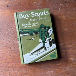 children's chapter book, children's boy scout adventure book - Boy Scouts in a Submarine or Searching an Ocean Floor written by G. Harvey Ralphson - view of the embossed front cover with an imagine of a boy scout getting into a submarine hatch