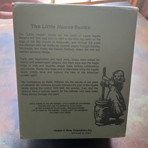 Little House on the Prairie Box Set in Blue written by Laura Ingalls Wilder with Illustrations by Garth Williams-vintage children's chapter books-view of the back of the box with information about the series on it along with an illustration of Mary churning butter