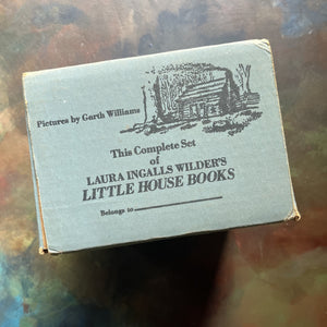 Little House on the Prairie Box Set in Blue written by Laura Ingalls Wilder with Illustrations by Garth Williams-vintage children's chapter books-view of the top of the box with a log cabin drawn on it