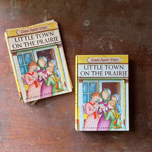 vintage children's chapter book-Newbery Honor Book - Little Town on the Prairie with dust jacket written by Laura Ingalls Wilder with illustrations by Garth Williams - view of the front cover with an illustration depicting Mary holding a kitten surrounded by other girls