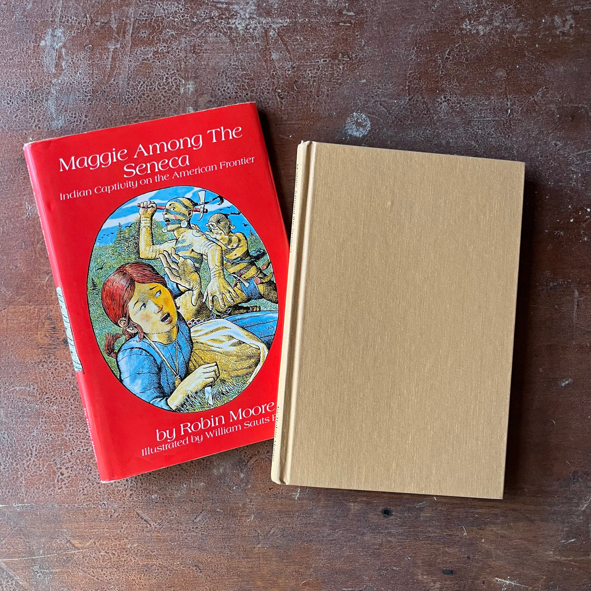 Maggie Among the Seneca:  Indian Captivity on the American Frontier written & Autographed by Robin Moore with illustrations by William Sauts Bock-view of the front cover in a solid tan color with the dust jacket in the background in a bright red with an illustration in the middle