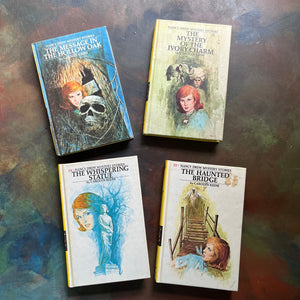 Set of Four Nancy Drew Mysteries written by Carolyn Keene-Books Twelve - Fifteen:  The Mystery in the Hollow Oak, The Mystery of the Ivory Charm, The Whispering Statue, and the Haunted Bridge-view of the front covers