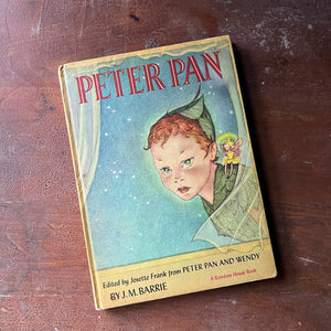 vintage children's chapter book, J. M. Barrie's Peter Pan & Wendy - Peter Pan a 1957 Edition Edited by Josette Frank with illustrations by Marjorie Torrey - view of the front cover with an illustration of Peter Pan & Tinker Bell gazing through an open window