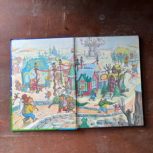 vintage children's picture book, 1980's Children's Literature - The Berenstain Bears' Christmas Tree written & illustrated by Stan and Jan Berenstain - view of the inside cover illustration featuring the town all decorated for Christmas with the Bear family walking down a bridge into town