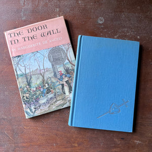 vintage children's chapter book, Newbery Medal Winner - The Door in the Wall written & illustrated by Marguerite De Angeli - view of the front cover with a sword embossed in silver on a blue background