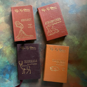 The Easton Press 50th Anniversary Leatherbound Editions-Peterson Field Guides-Set of Four-Geology, Mammals, Atmosphere and Freshwater Fish-view of the leatherbound front covers with gold embossing