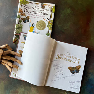 The Girl Who Drew Butterflies-How Maria Merian's Art Changed Science-written by Joyce Sidman with illustrations by Maria Merian-a Robert F. Sibert Medal Winner-living science children's book-view of the half title page with two inscriptions written in ink.