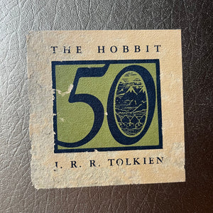 vintage children's chapter book, special edition book, classic literature - The Hobbit written and illustrated by J. R. R. Tolkien-50th Anniversary Edition in Sleeve - view of a closeup of the sticker from the book sleeve showing the condition of the sticker