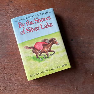 Log Cabin Vintage – vintage children’s book, children’s book, chapter book, Little House on the Prairie Series – By the Shores of Silver Lake by Laura Ingalls Wilder with Illustrations by Garth Williams - view of the dust jacket's front cover