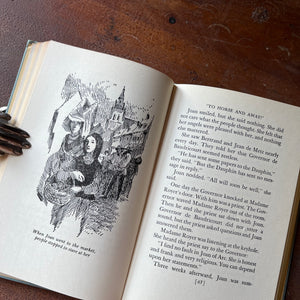 The Story of Joan of Arc Signature Series Children's Chapter Book by Jeannette C. Nolan - View of an inside page with full page illustration sitting on a wood table